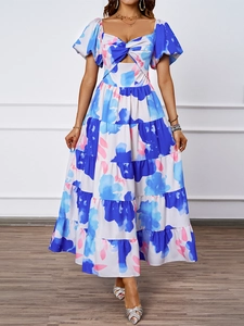 Dettaglio maxi abito floreale con spalle scoperte, gonna a balze e cut-out frontale