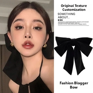 Close-up of elegant black velvet oversized bow hair clip with premium fabric texture