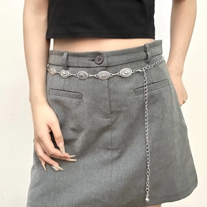 Retro Bohemian silver metal chain belt with embossed oval accents for women on grey skirt