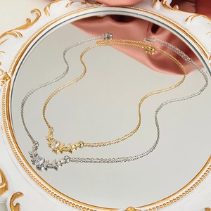 Close-up of gold and silver elk pearl necklaces reflected on a decorative mirror