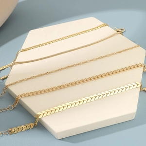 Detailed view of five gold Bohemian chain bracelets in varied styles on a hexagonal base
