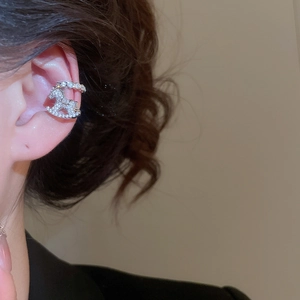 Detailed view of silver rocking horse ear cuff with white zircons on model ear