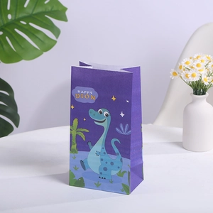 Detail of purple cartoon dinosaur paper gift bag featuring Happy Dino print on a white table