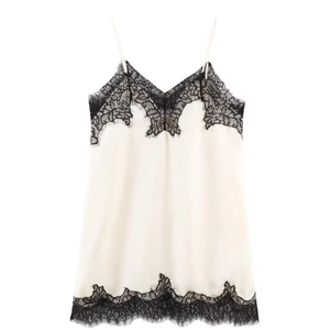 Detail view of satin camisole featuring black floral lace trim and delicate spaghetti straps
