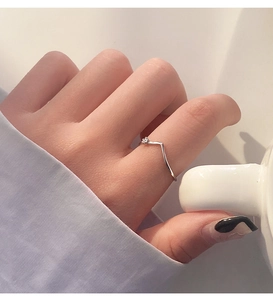 Detailed view of s925 silver V-shaped ring with a single sparkling diamond on finger