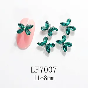 Vista macro de dijes de mariposa 3D verdes de 11x8mm con base plateada para decoración DIY