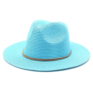 Detail of teal straw fedora hat featuring woven texture and decorative brown leather band