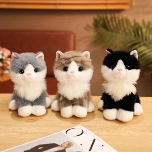 Three realistic plush cats in grey, brown tabby, and black on a wooden table