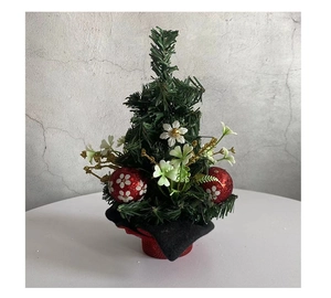 Detailed view of mini Christmas pine tree with red glitter balls and black cloth base