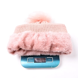 Bonnet en tricot rose avec doublure en fausse fourrure et pompon, pesant 104g sur balance