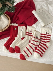 Detail of five pairs of warm Christmas socks with festive embroidery and cable knit texture