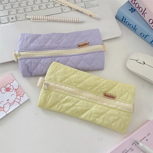 Pastel quilted pencil cases in purple and yellow colors with soft fabric texture