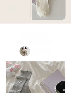 Detailed view of white cotton socks with lace ruffle cuffs and heart embroidery accents
