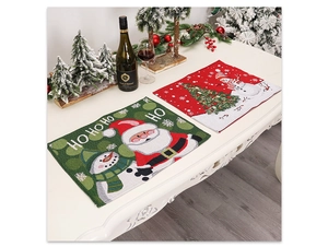 Détail d'un set de table de Noël avec Père Noël et texte HO HO HO sur une table dressée