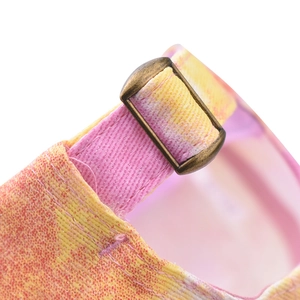 Detail of glitter tie-dye fabric and vintage bronze metal buckle on baseball cap back