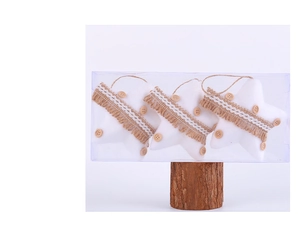 Détail de trois ornements de Noël en étoile blanche avec jute et dentelle en boîte