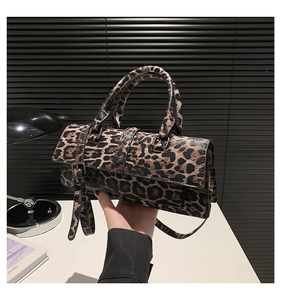 Detail of leopard print PU leather handbag with circular handles and adjustable strap