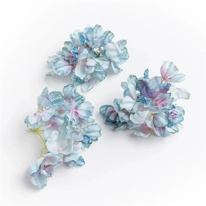 Detailed view of three blue and pink gradient faux hydrangea flowers for DIY crafts