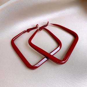 Retro burgundy red square hoop earrings displayed on elegant beige silk fabric