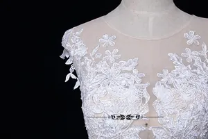 Gros plan détaillé de la broderie de dentelle florale blanche sur le col de la robe de mariée