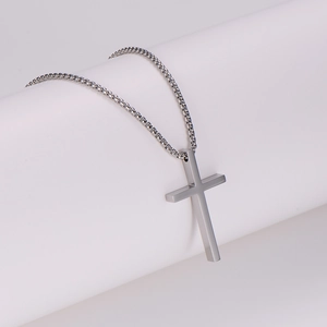 Minimalist silver stainless steel cross necklace with pearl chain on white podium