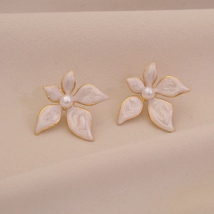 Elegant white enamel flower stud earrings with gold plating and central faux pearls