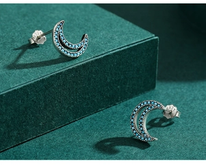 Macro shot of silver crescent moon earrings with turquoise stone and S925 hallmark stamp