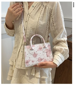 Détail du sac cabas blanc avec imprimés papillons violets et bandoulière amovible