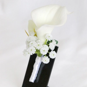 Elegant white calla lily wedding boutonniere for groom with satin ribbon and gypsophila