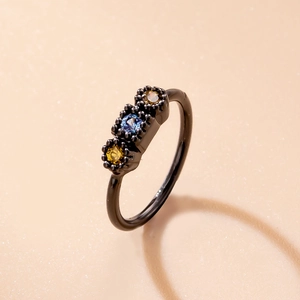 Close-up of black nose ring with micro-set blue and yellow cubic zirconia stones