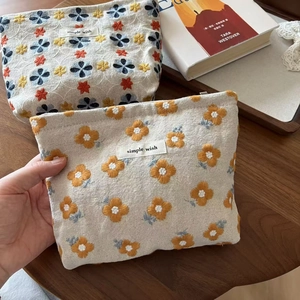 Close-up of floral embroidery on cotton linen pouch with simple wish textile label