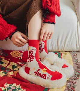 Detail showing red festive socks with embroidered lucky characters and knit texture