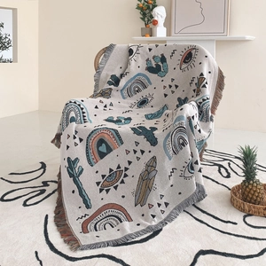 Close-up of bohemian woven blanket featuring cactus patterns and colorful tassels