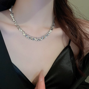 Close-up of silver sequin tassel necklace showing shiny metal geometric pendants