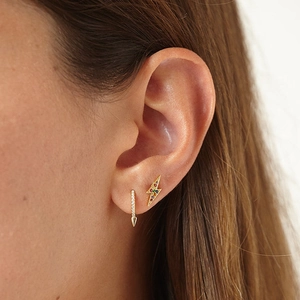 Close-up of golden lightning stud and hoop earring set with colorful zircon stones