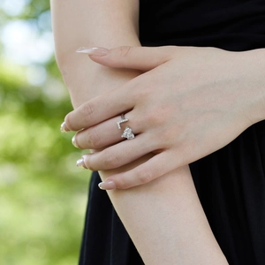 Detail view of silver adjustable heart ring with sparkling zircons on model's hand