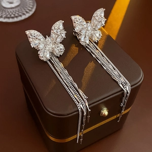 Detail view of silver butterfly ear cuff with sparkling zircon and long chain tassels