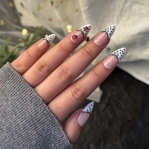 French tip press-on nails with black polka dots, bows, and red ladybug nail art designs
