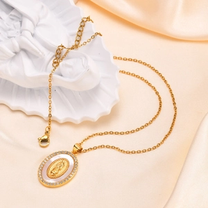 Macro shot of oval Virgin Mary pendant with gold plating and shimmering pearl shell