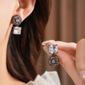 Detail view of vintage floral earrings with square zircon crystals in black gold finish