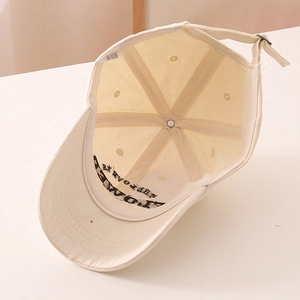 Détails intérieurs d'une casquette en coton beige avec sangle réglable et broderie