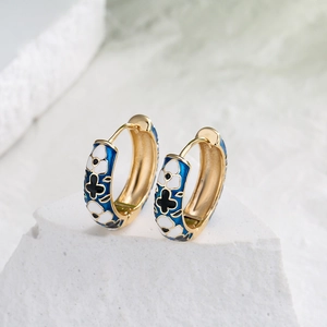 Vintage 18K gold plated hoop earrings with blue enamel floral pattern on stone pedestal