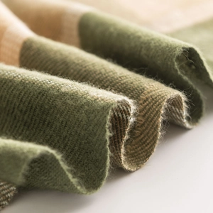 Detailed macro view of soft plaid cashmere-like fabric texture in green and tan tones