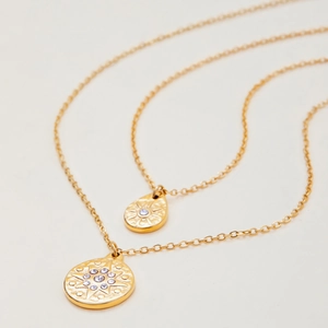 Golden double-layer stainless steel necklace featuring sunburst drop and coin pendants