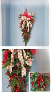Detail of Christmas swag with pine needles, red berries, pine cones and rustic metal bells
