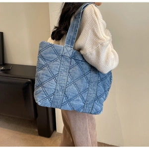 Détail du grand sac cabas matelassé bleu denim montrant la texture du tissu en jean