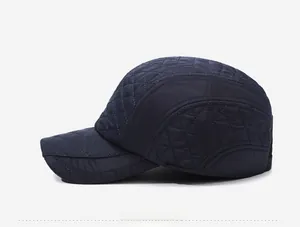 Side view of dark blue quilted baseball cap with ear flaps and fine embroidery details