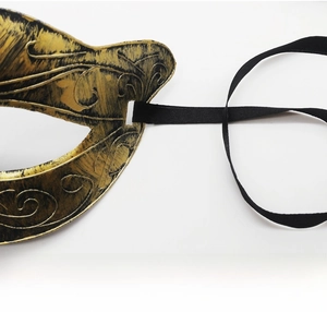 Détail du masque de fête doré antique avec motifs en relief et ruban de soie noire