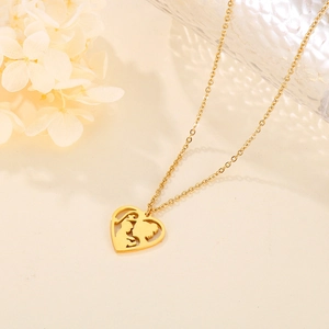 Macro detail of gold heart pendant featuring a mother and child silhouette on a fine chain
