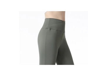 Detail of cross-over high waist on olive green flared yoga pants showing tummy control